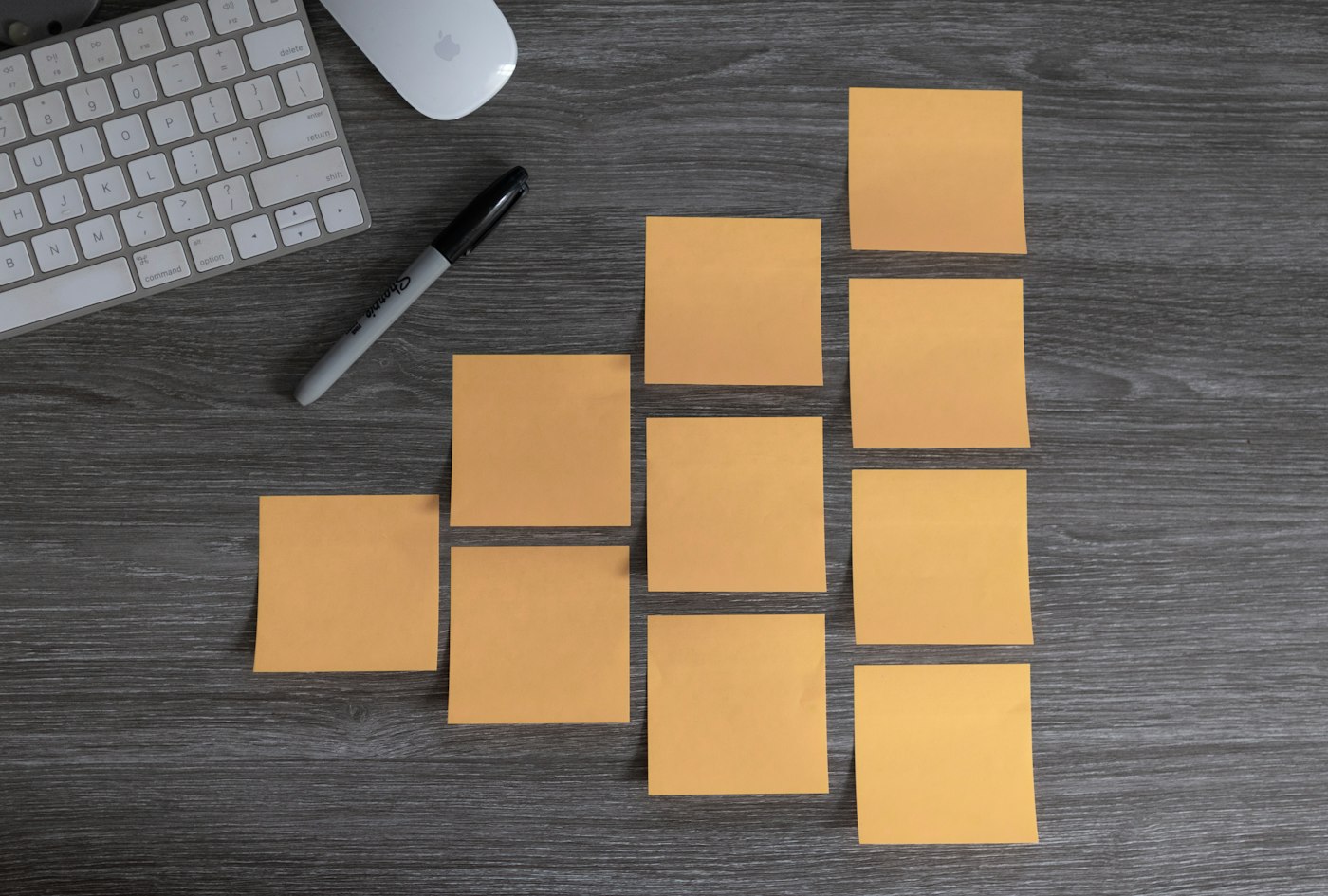 Notes adhésives organisées en colonnes sur un bureau sombre